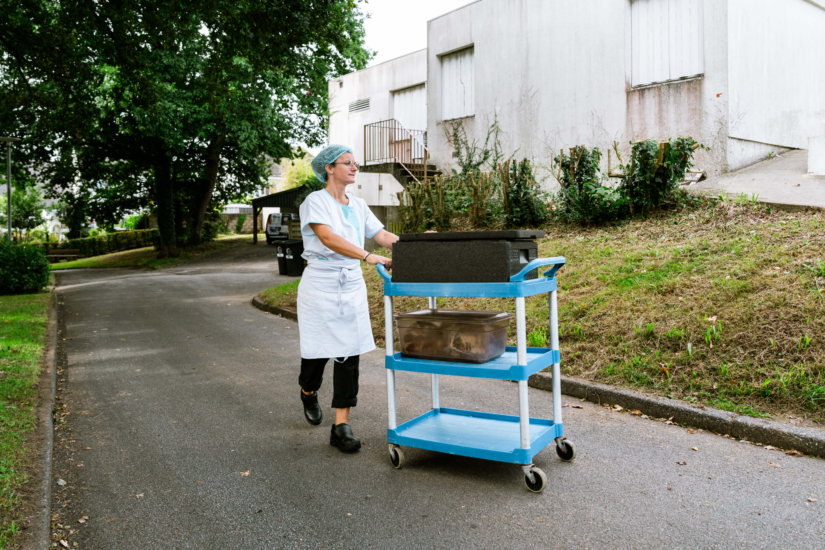Dame poussant un chariot de cantine à Auray