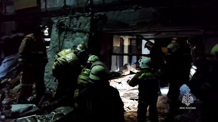 Capture d'écran d'une séquence diffusée par le ministère des Situations d'urgence de la Russie, le 3 février 2024, qui montre des sauveteurs dans les décombres de la boulangerie détruite par un bombardement à Lyssytchansk, dans l'est de l'Ukraine. (RUSSIAN EMERGENCIES MINISTRY / AFP)